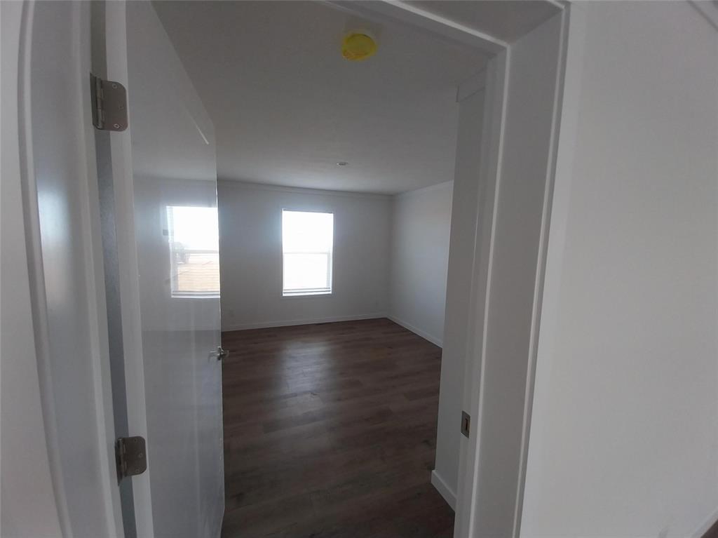 Image 12 of 28: Spare room with dark wood-style flooring and a smoke detector