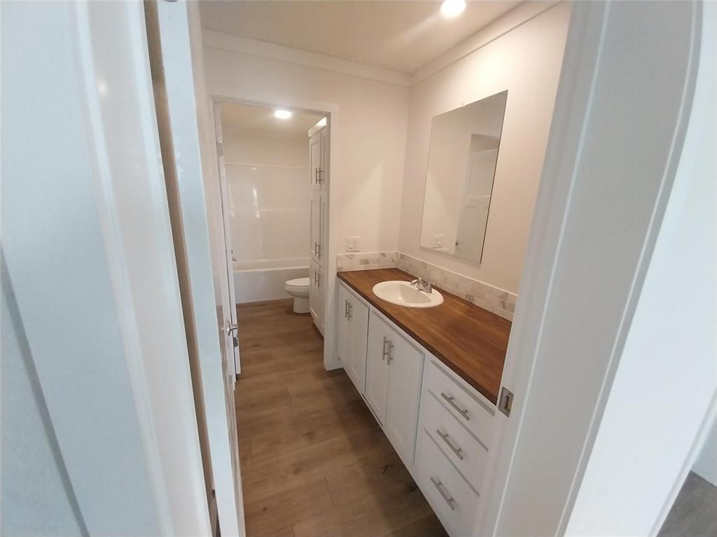 Image 14 of 28: Bathroom with vanity, light wood-type flooring, shower / tub combination, a