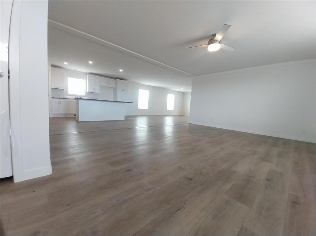 Image 2 of 28: Unfurnished living room featuring dark wood-style floors, recessed lighting