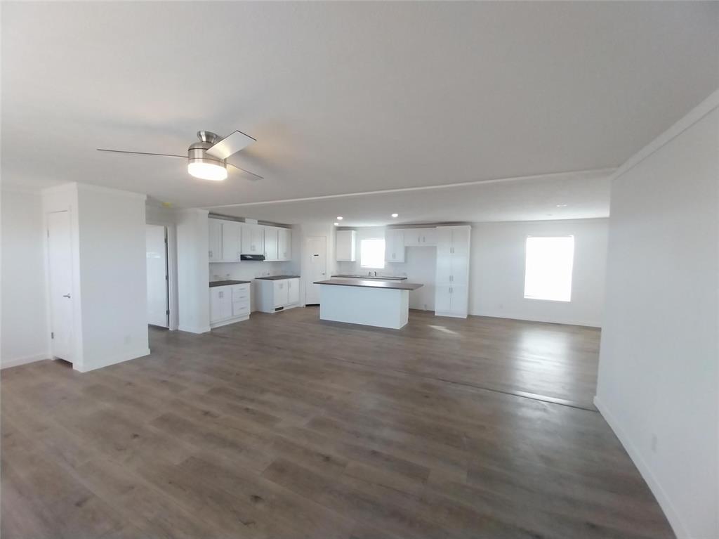 Image 8 of 28: Unfurnished living room with plenty of natural light, dark wood-type floori