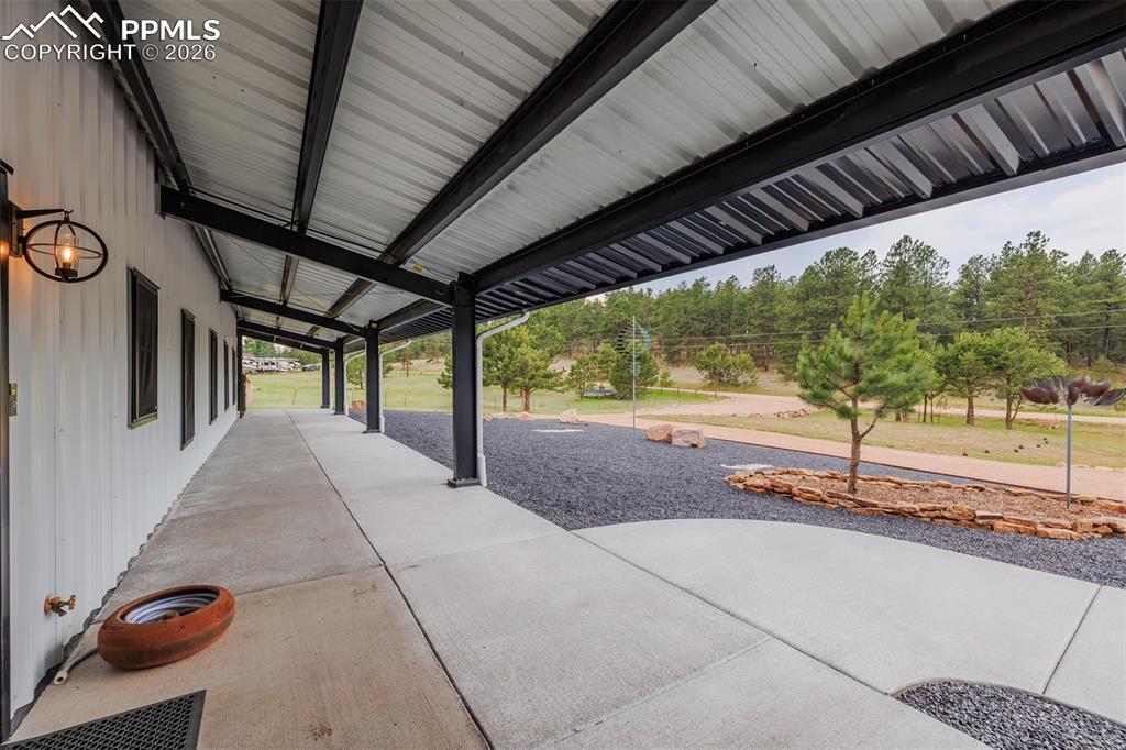 Image 5 of 38: Front covered patio that wraps around to the side