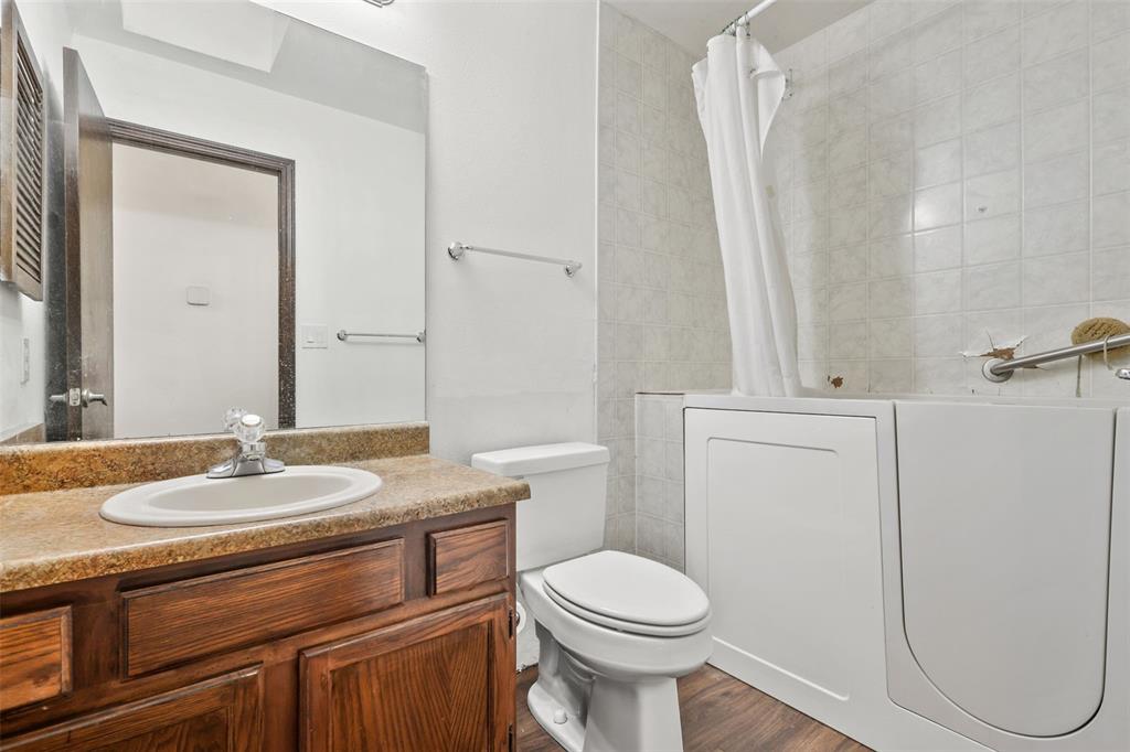 Image 14 of 32: Full bathroom with vanity and walk-in tub and shower combination
