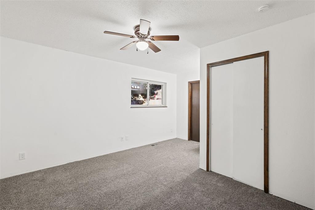 Image 17 of 32: Primary bedroom with a closet, ceiling fan and carpet flooring