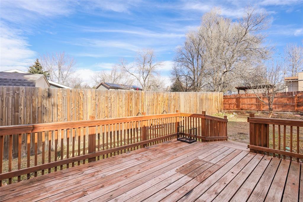 Image 21 of 32: Wooden terrace with a fenced backyard