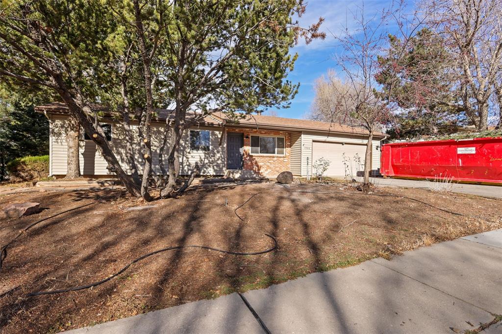 Image 28 of 32: Ranch-style home featuring a garage, concrete driveway, and brick siding