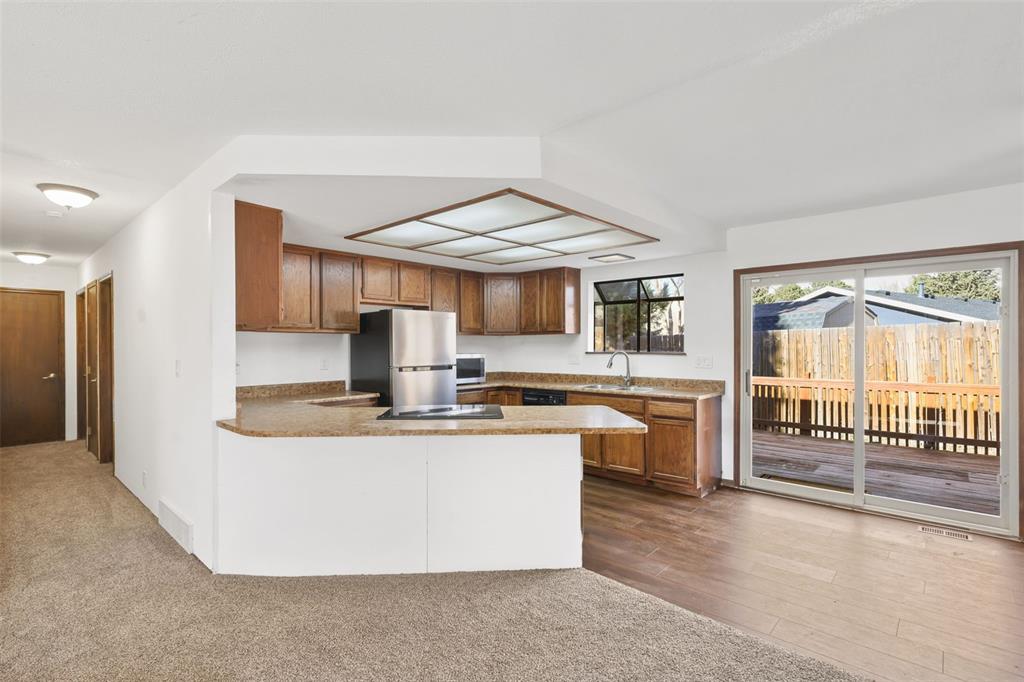 Image 6 of 32: Kitchen featuring wood cabinets, stainless steel refrigerator, and a garden