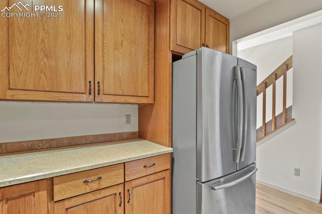 Image 10 of 30: Kitchen with freestanding refrigerator, light wood-style flooring, and brow
