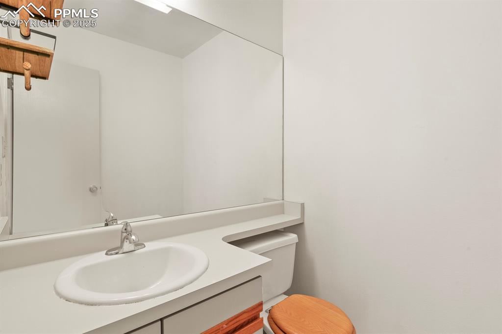 Image 11 of 30: Half bath with vanity and toilet on the main floor