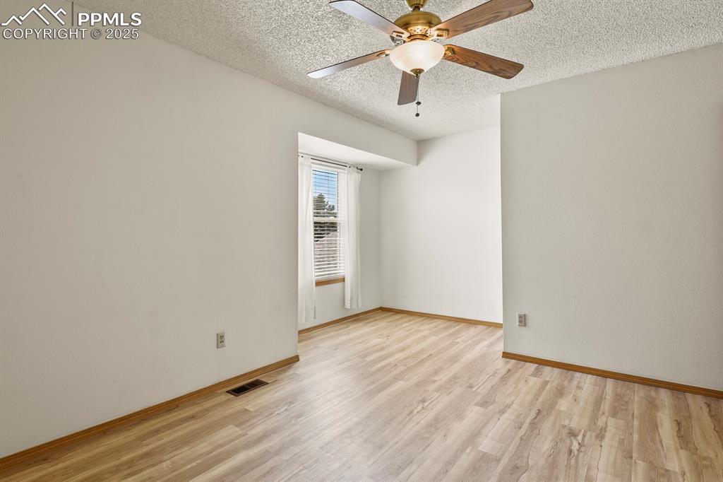 Image 13 of 30: Main Bedroom with light wood-type flooring, and ceiling fan
