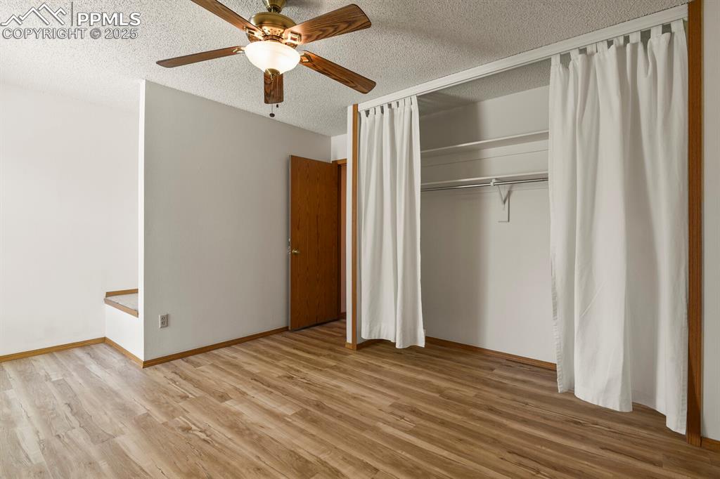 Image 14 of 30: Main bedroom featuring a textured ceiling, wood finished floors, a closet, 
