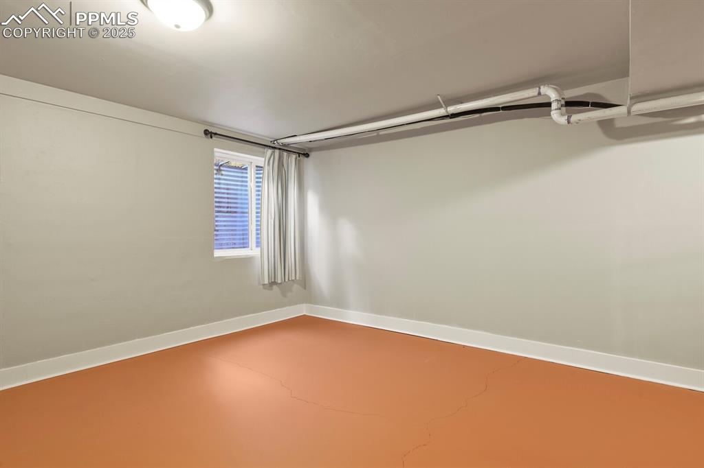 Image 19 of 30: Large bedroom-family room in basement with concrete flooring