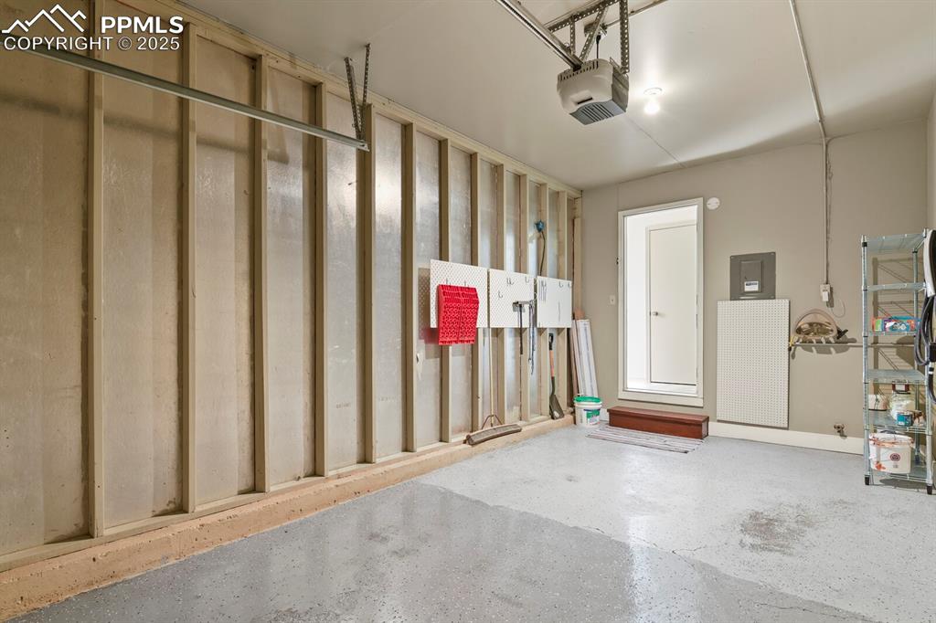 Image 26 of 30: Garage featuring electric panel and a garage door opener
