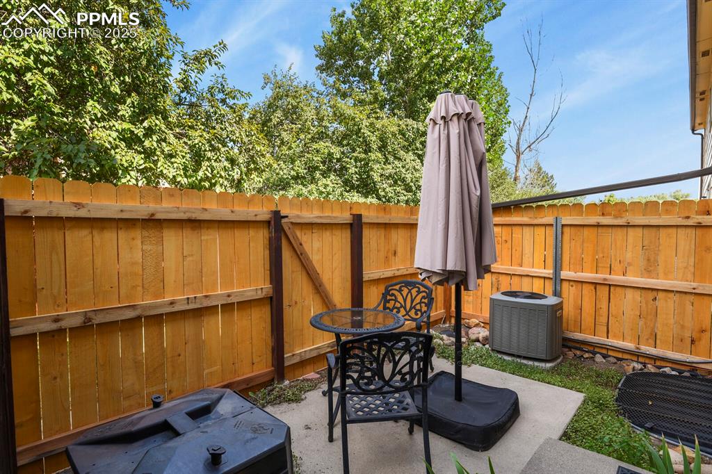 Image 29 of 30: Fenced backyard with a patio