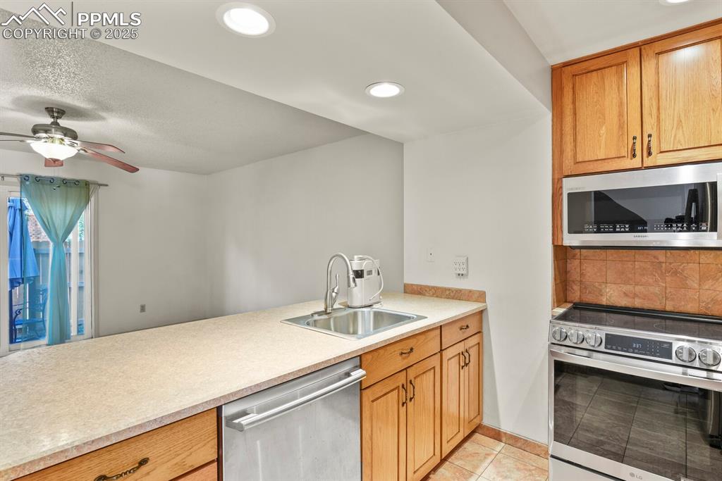 Image 7 of 30: Kitchen featuring appliances with stainless steel finishes, light tile patt