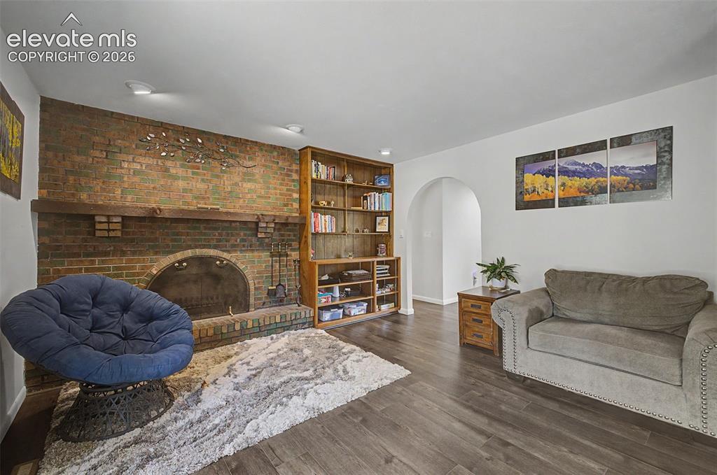Image 10 of 43: Cozy family room features a wood-burning fireplace, built-in storage, and w