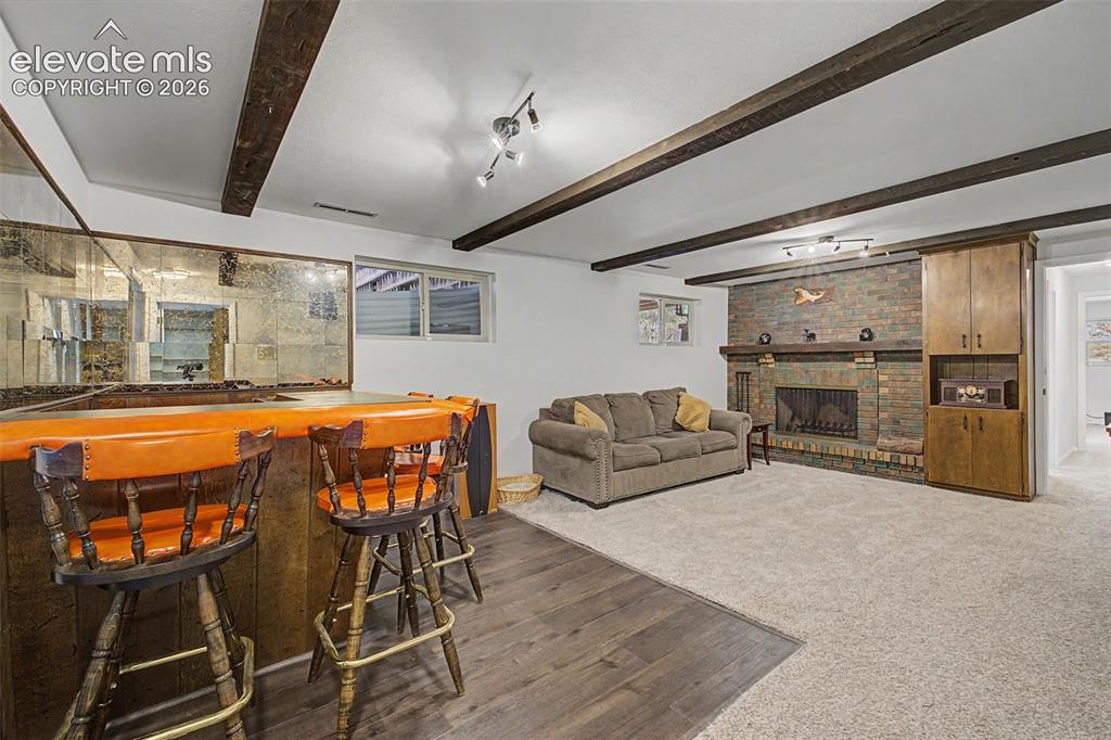 Image 23 of 43: Head downstairs to enjoy the spacious second family room featuring a beamed