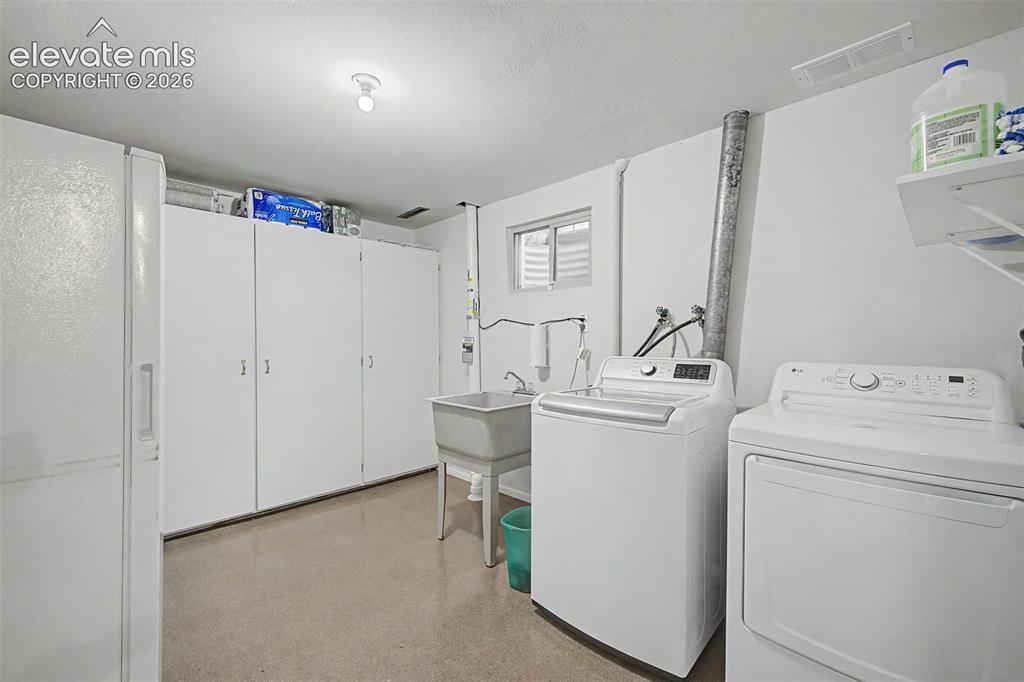Image 29 of 43: The massive laundry room features a sink, window, and built-in storage cabi