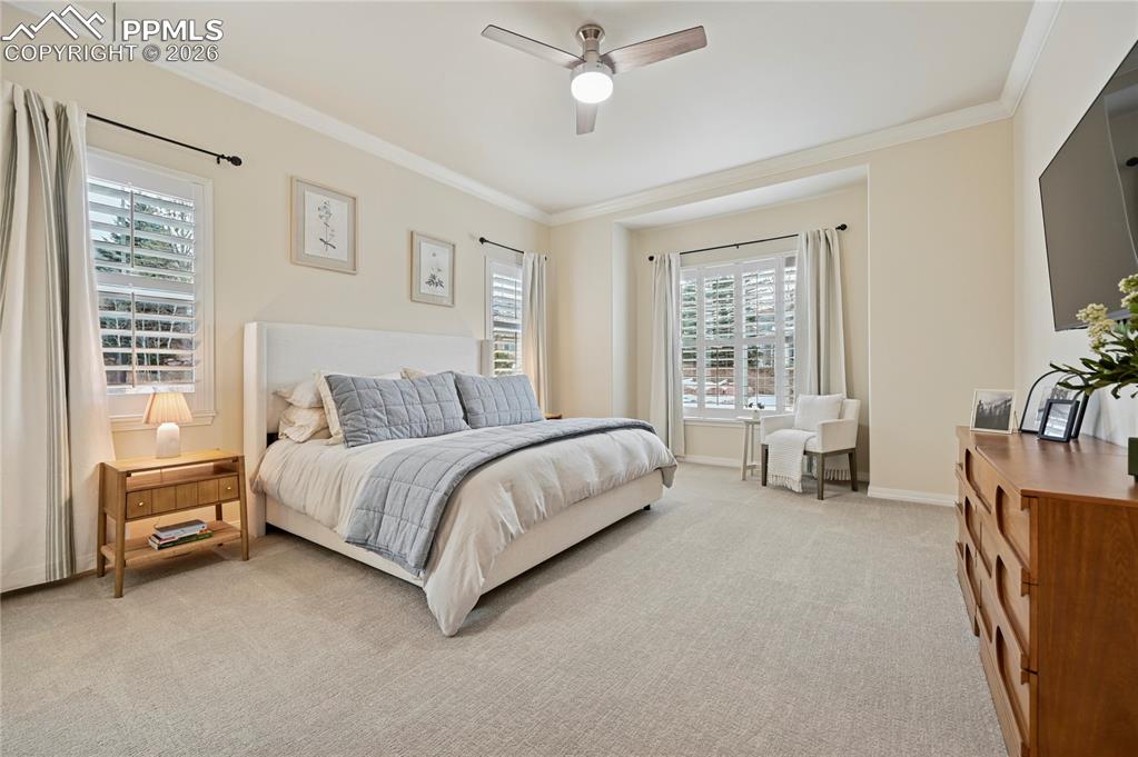 Image 17 of 50: Bedroom featuring carpet floors, ornamental molding, and a ceiling fan