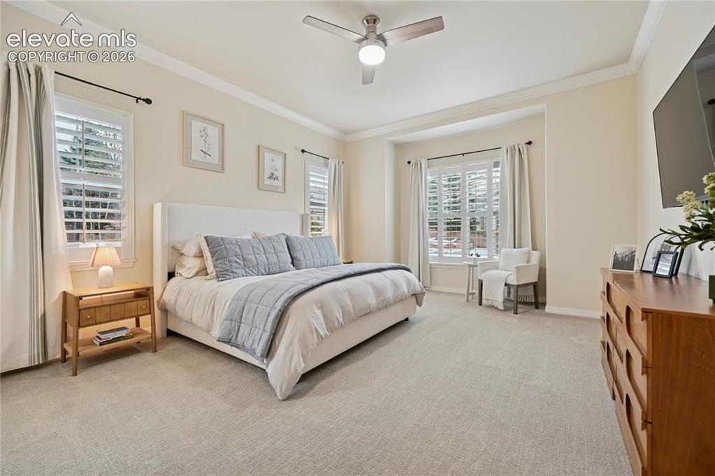 Image 17 of 49: Bedroom featuring carpet floors, ornamental molding, and a ceiling fan