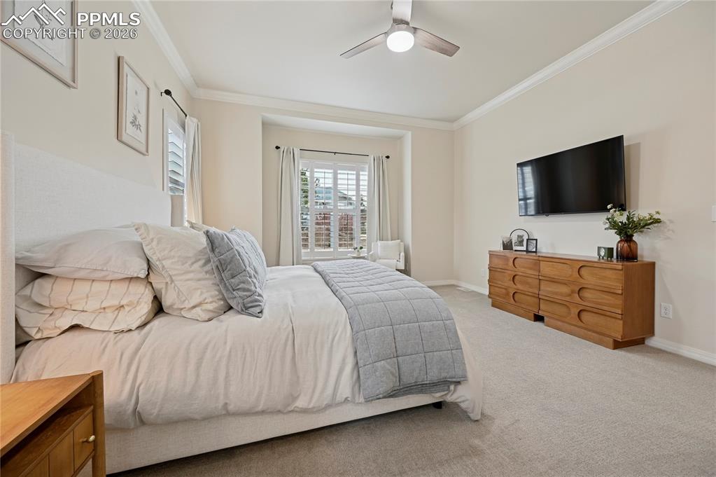 Image 18 of 50: Bedroom featuring ornamental molding, carpet, and a ceiling fan