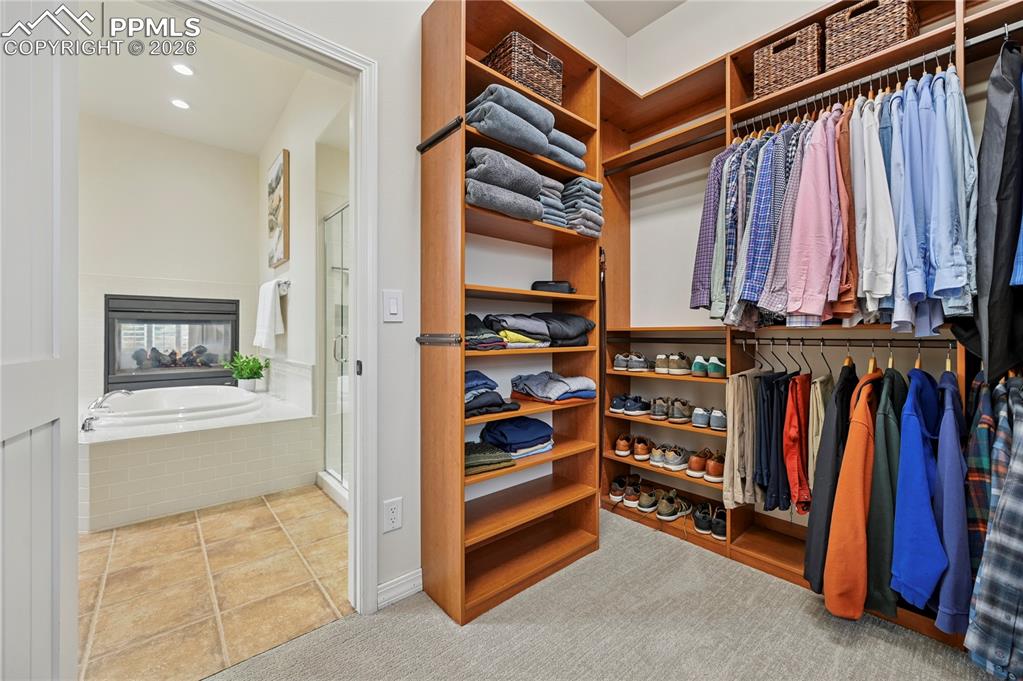 Image 22 of 50: Walk in closet featuring light colored carpet and light tile patterned floo