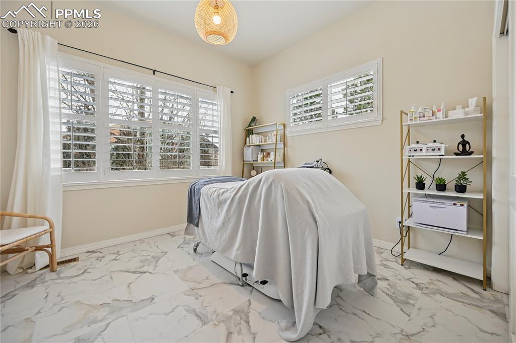 Image 25 of 50: Bedroom featuring baseboards and light marble finish floors
