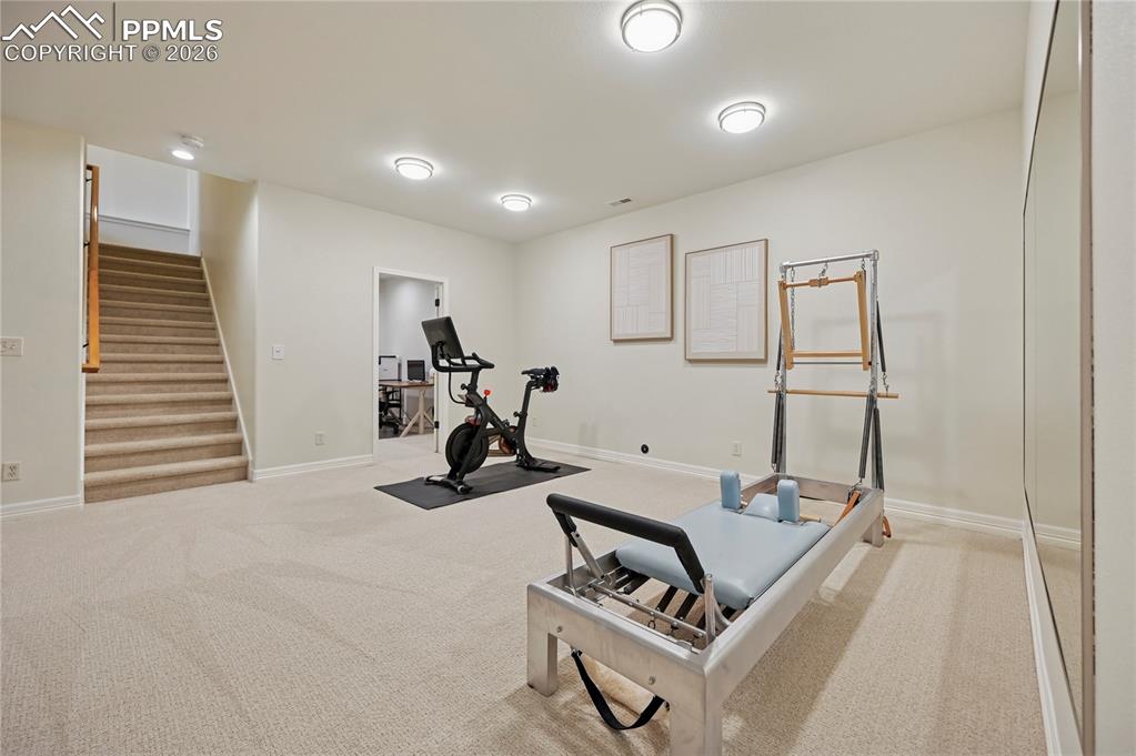 Image 29 of 50: Exercise area featuring light colored carpet and baseboards