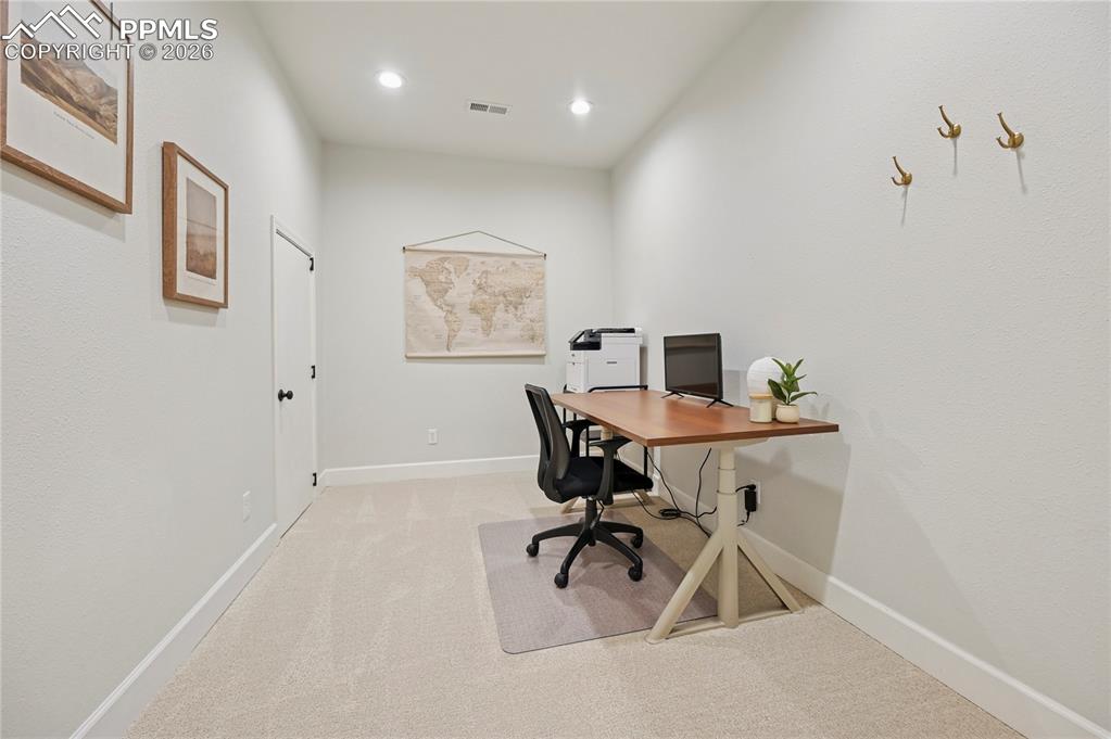 Image 30 of 50: Office space with light carpet and recessed lighting