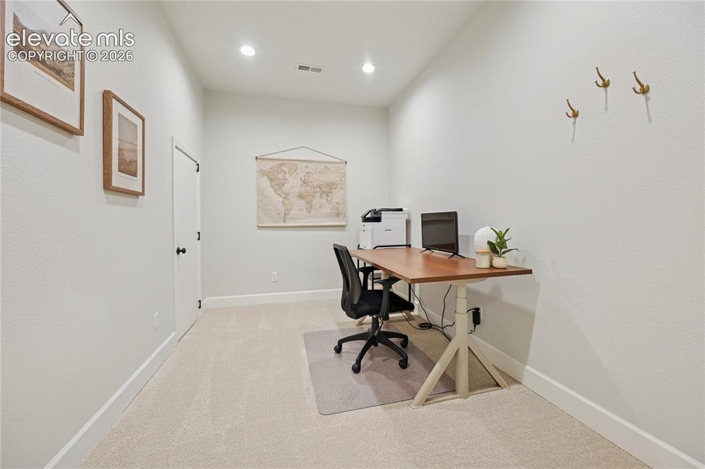 Image 30 of 49: Office space with light carpet and recessed lighting