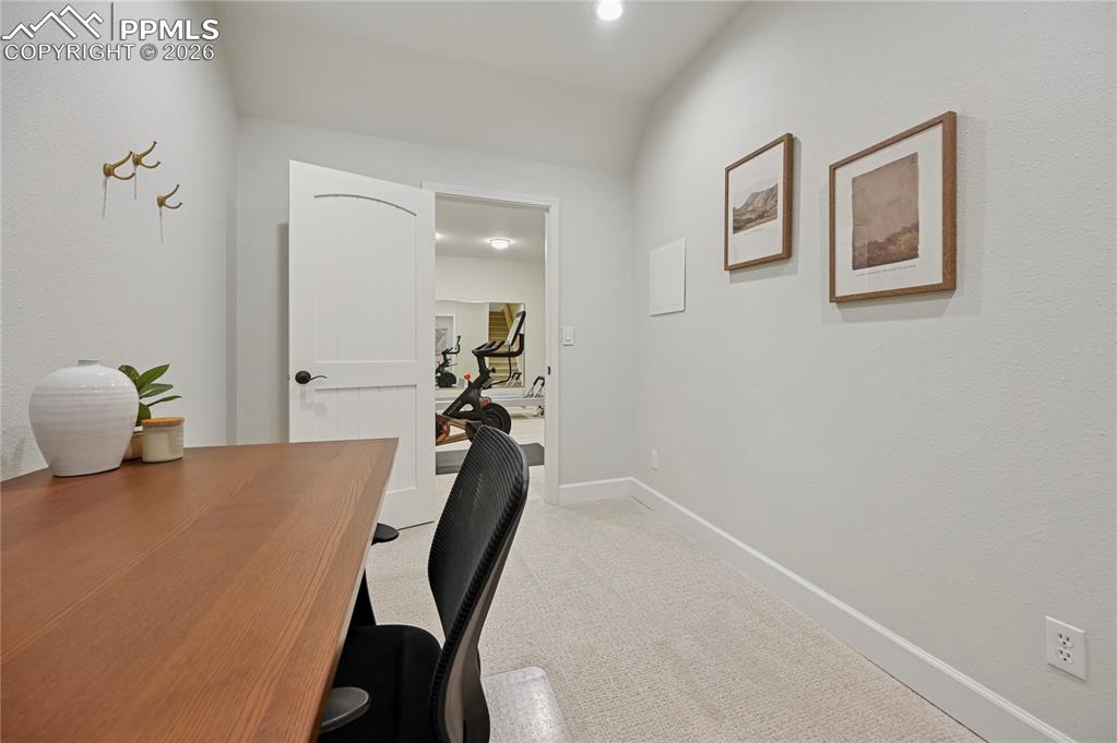 Image 31 of 50: Home office featuring light carpet and vaulted ceiling