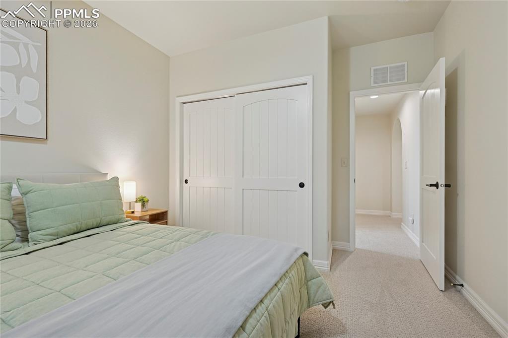 Image 35 of 50: Bedroom with light colored carpet and a closet