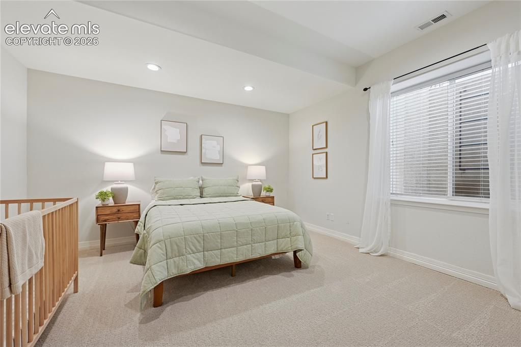 Image 38 of 49: Bedroom with light carpet and recessed lighting
