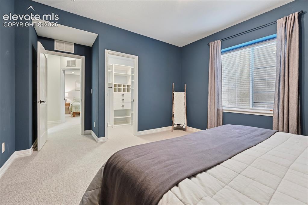 Image 40 of 49: Bedroom with a walk in closet and carpet floors
