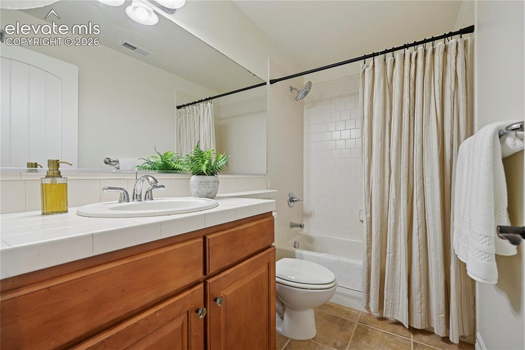 Image 42 of 49: Full bath with shower / bath combo, vanity, and light tile patterned floors