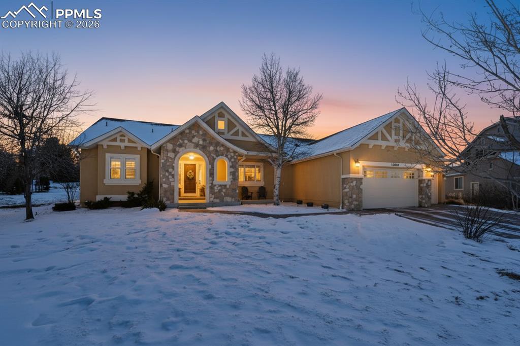 Image 48 of 50: View of front of house with stone siding and an attached garage