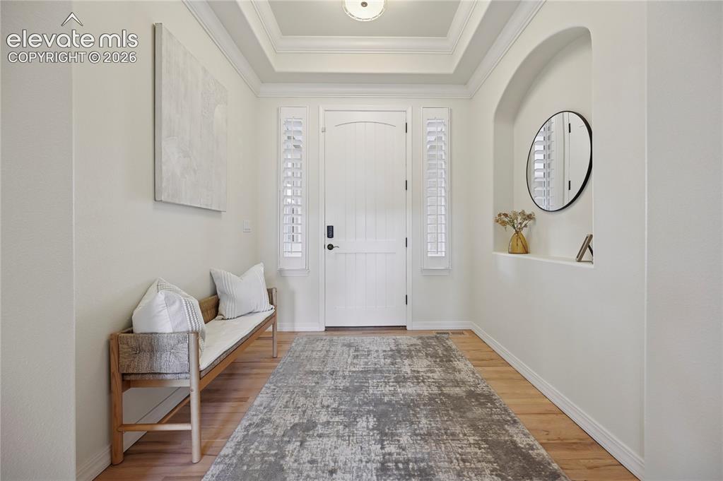 Image 5 of 49: Foyer entrance featuring a raised ceiling, light wood-style flooring, and c
