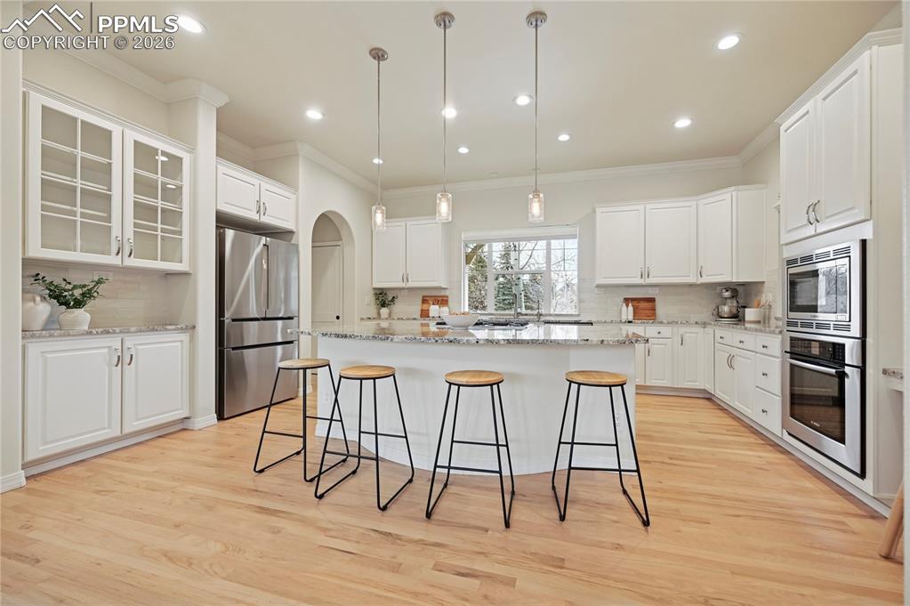 Image 6 of 50: Kitchen featuring pendant lighting, a breakfast bar, stainless steel applia