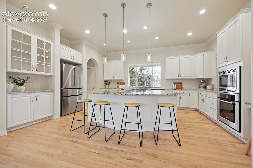 Image 6 of 49: Kitchen featuring pendant lighting, a breakfast bar, stainless steel applia