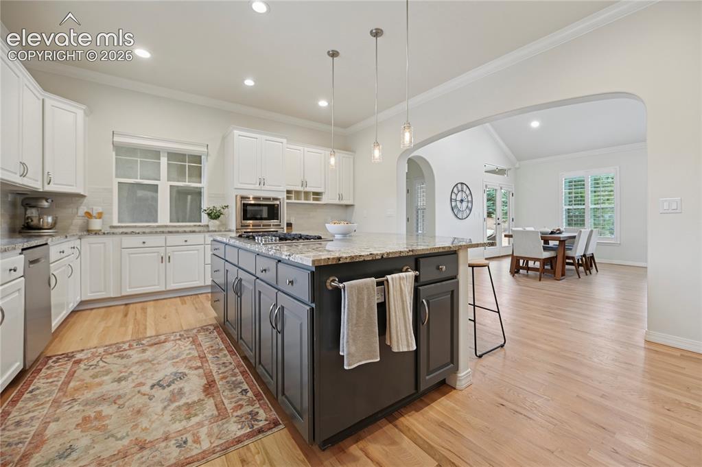 Image 9 of 49: Dual tone kitchen with dual tone cabinets, decorative backsplash, light sto