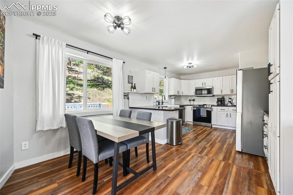 Image 13 of 49: Dining area with dark wood-style floors