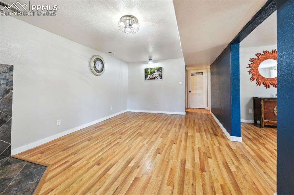 Image 31 of 49: Unfurnished living room featuring wood finished floors and baseboards