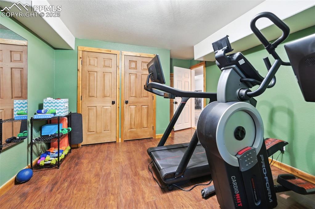 Image 35 of 49: Workout area featuring wood finished floors and a textured ceiling