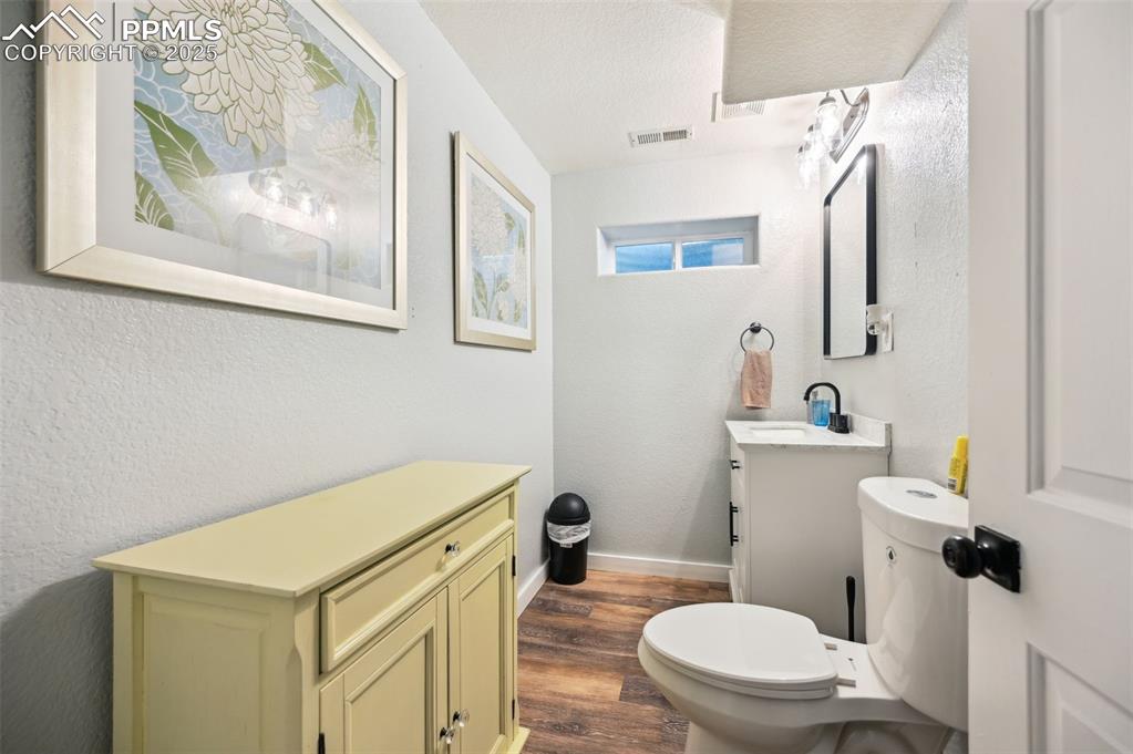 Image 36 of 49: Bathroom with vanity, wood finished floors, and a textured wall