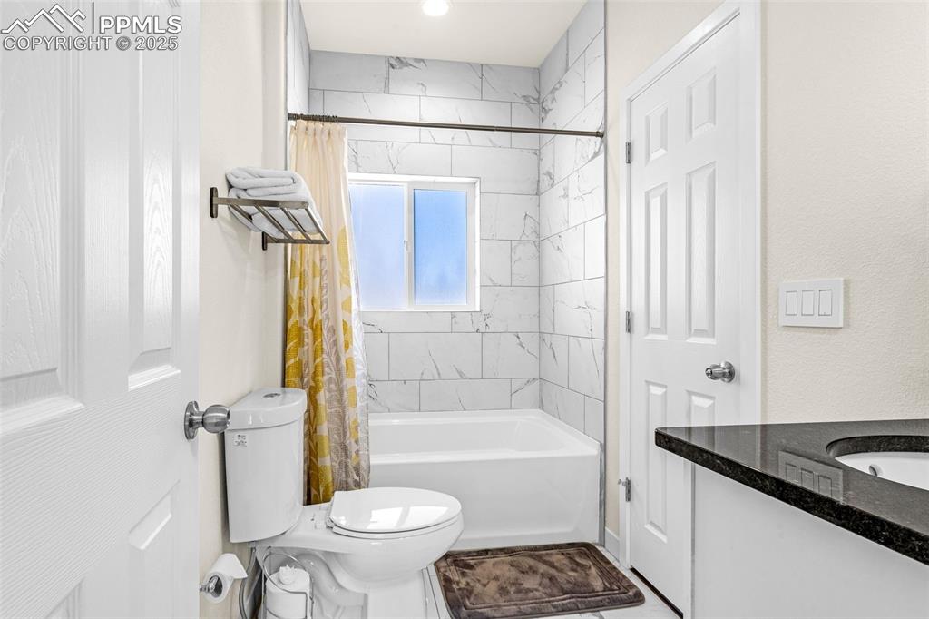 Image 12 of 37: Main level full bath with tile shower / tub and tile floor