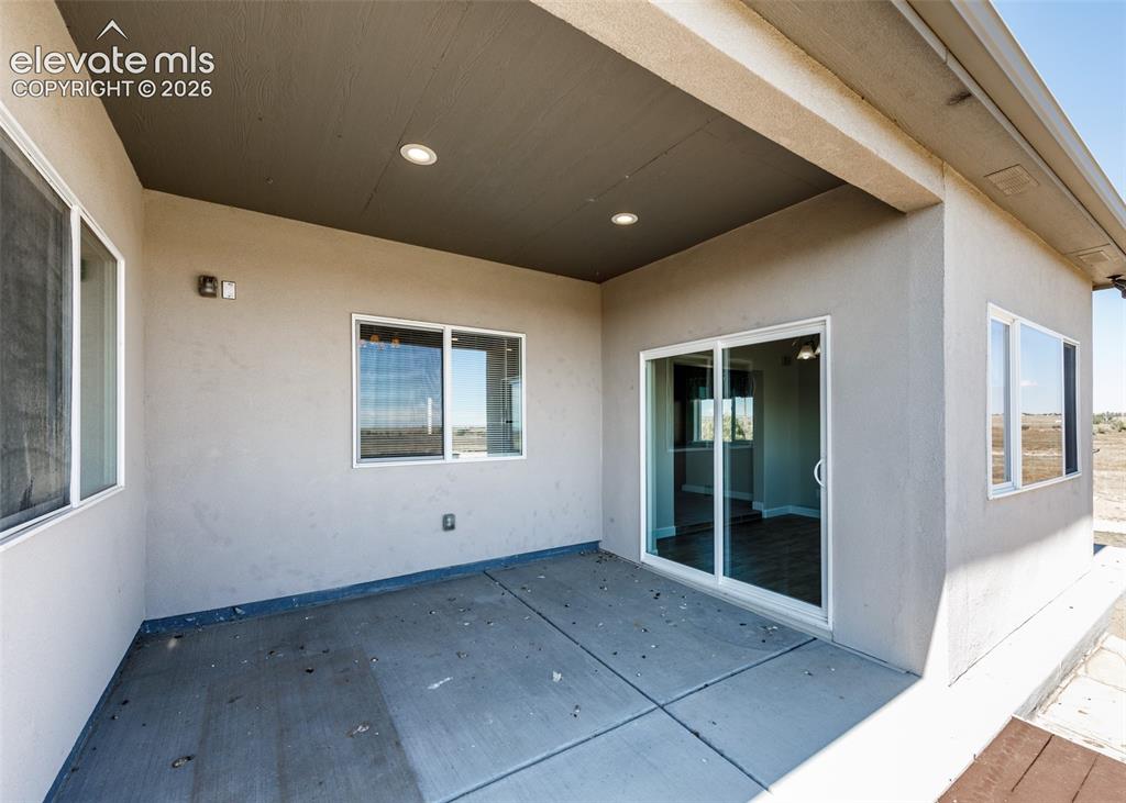 Image 12 of 27: Covered concrete patio.