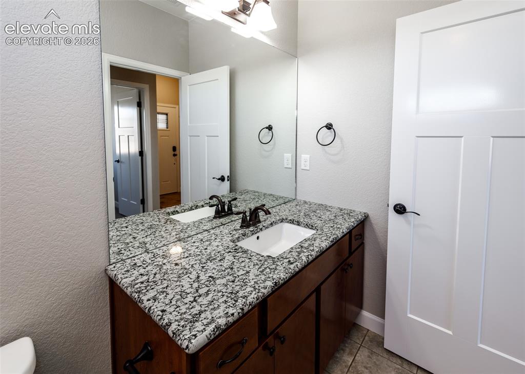 Image 13 of 27: Main full bath with beautiful granite vanity.