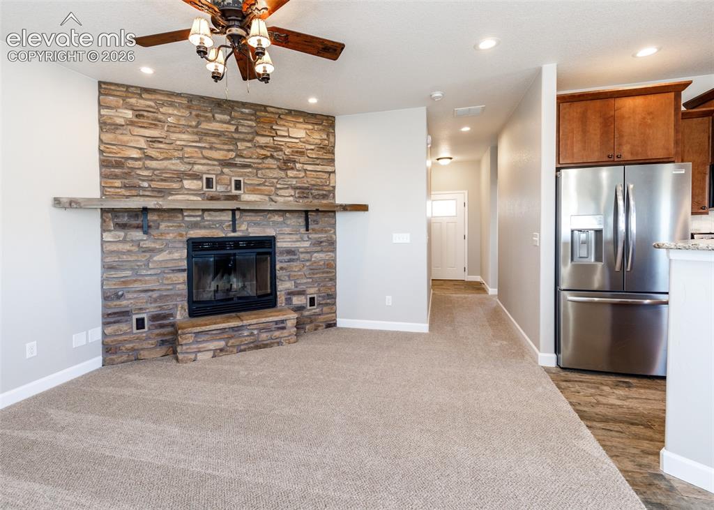 Image 6 of 27: Wood burning fireplace with stone surround warms the family room.