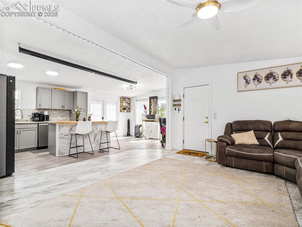 Image 11 of 29: Living room featuring a ceiling fan