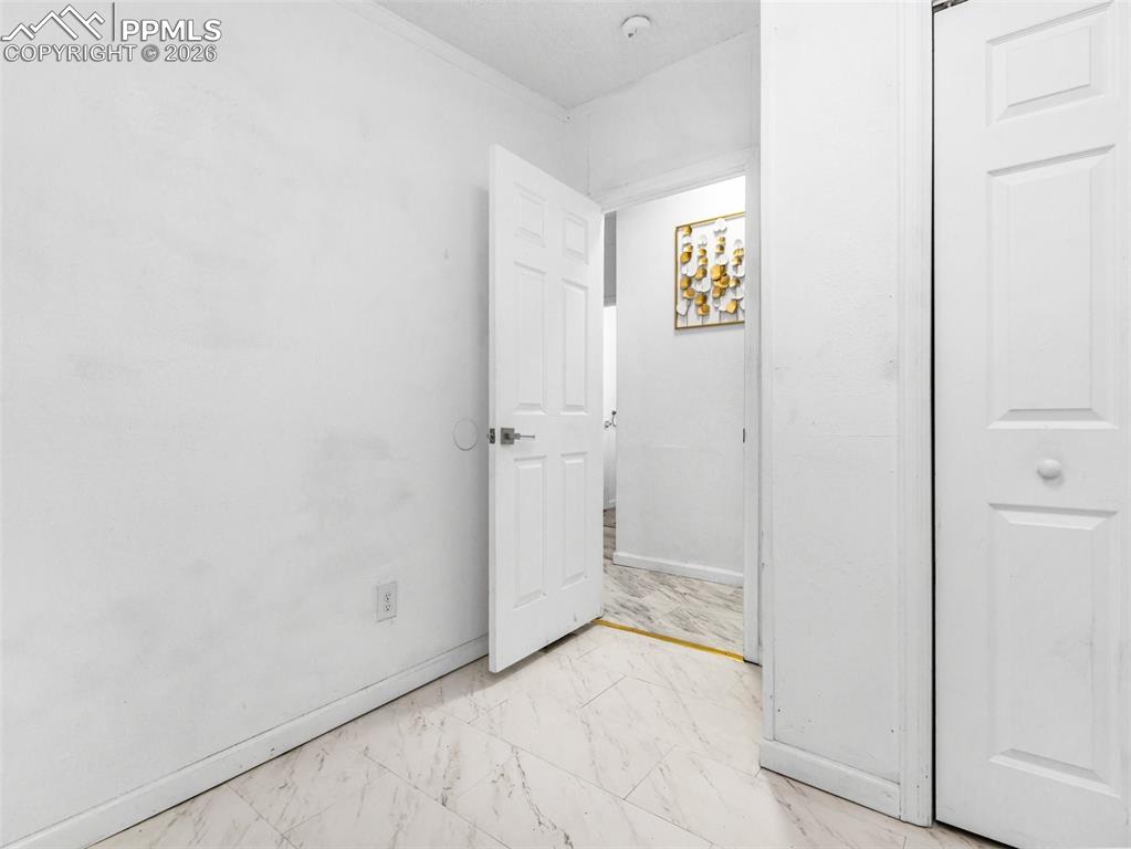 Image 19 of 29: Unfurnished bedroom featuring baseboards and light marble finish floors