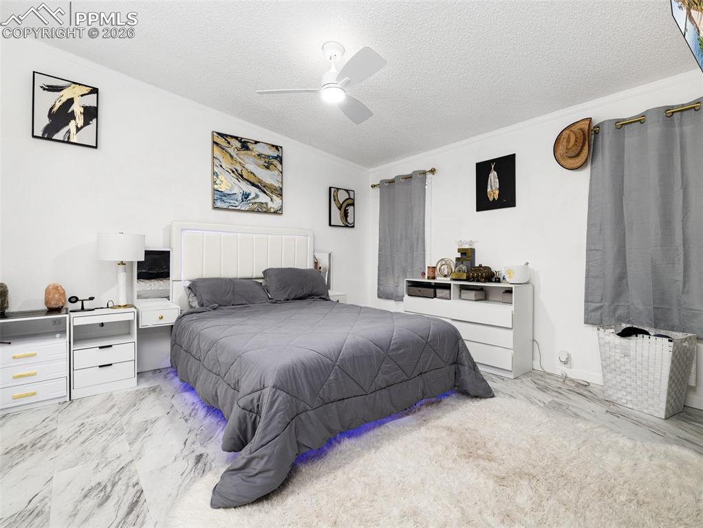 Image 20 of 29: Bedroom with a textured ceiling, ceiling fan, and radiator heating unit
